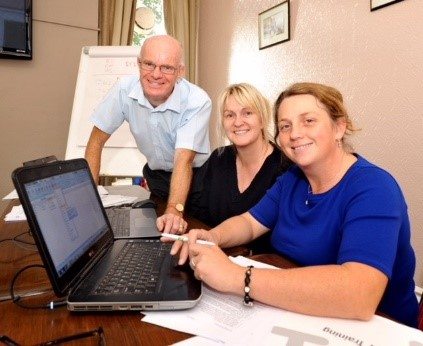 John Legge with two trainees from Women in Dairy for Excel training